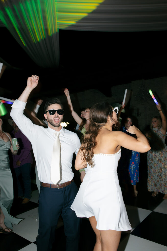 Wedding photography on film of the bride and groom dancing playfully.