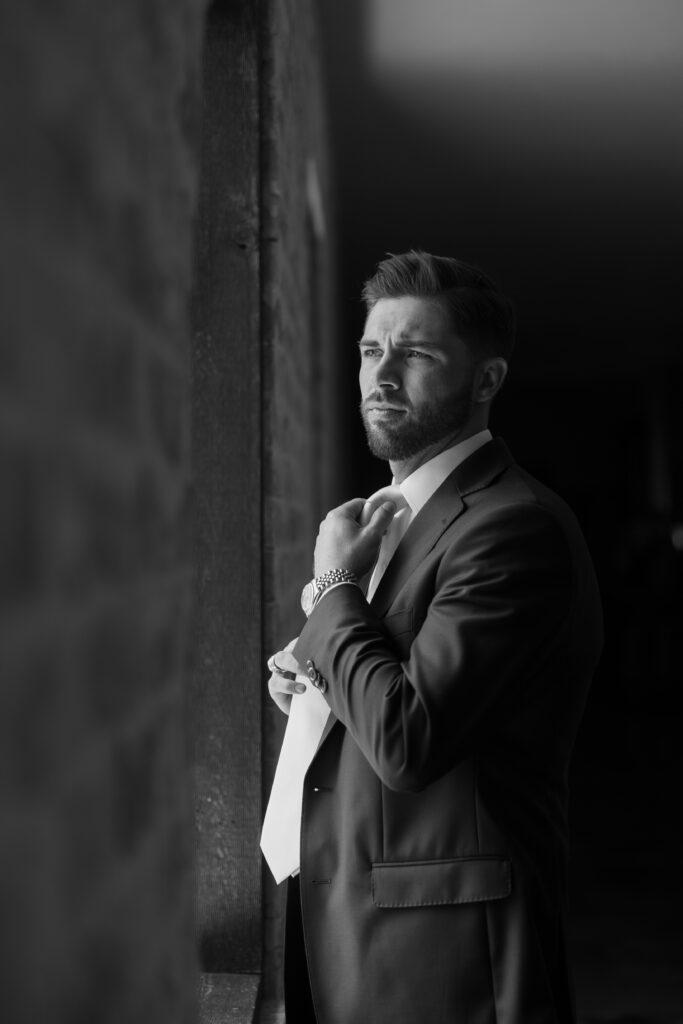 Wedding photography on film of groom looking off into the distance before the wedding ceremony.