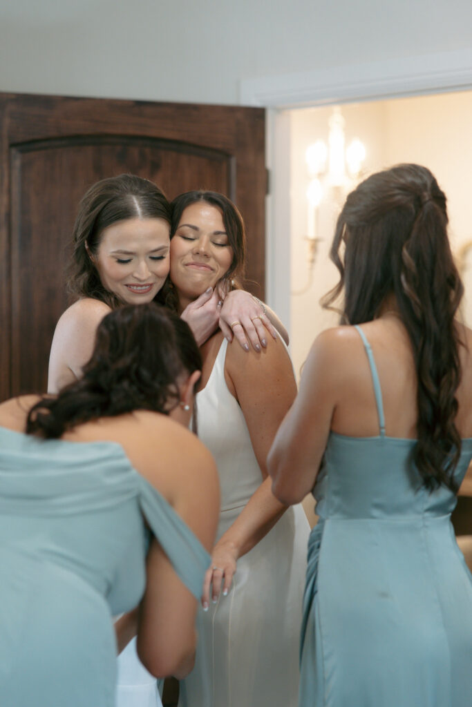 Bridal party hugging the bride after getting ready.
