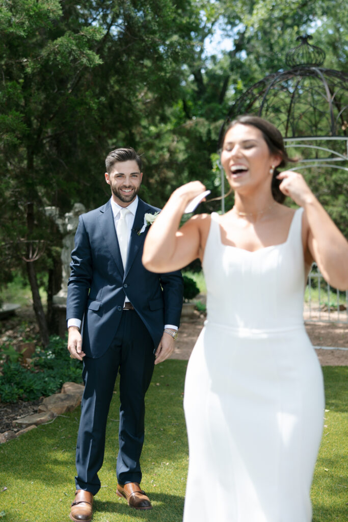 Groom standing behind the bride smiling.
