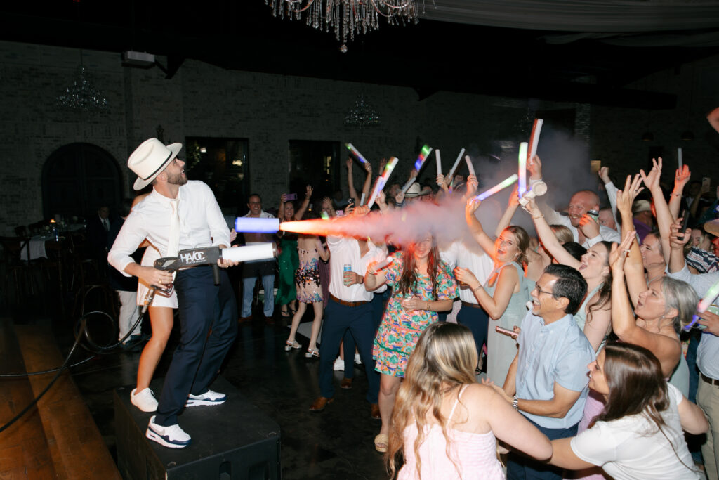 Bride blowing fog into the dancing crowd.