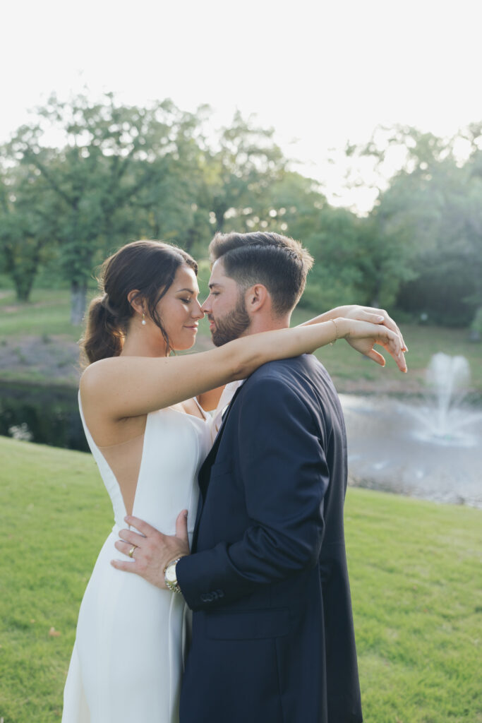 Bride with her arms around the neck of her husband.
