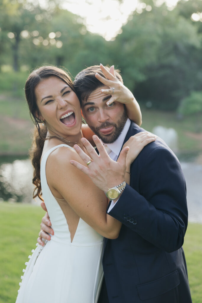 Bride and groom showing off their wedding rings.