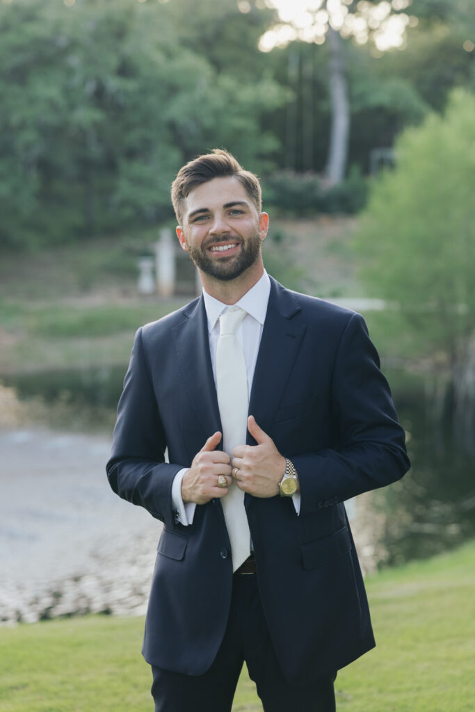 Wedding photography on film of groom standing by the water at La Bella Luna.