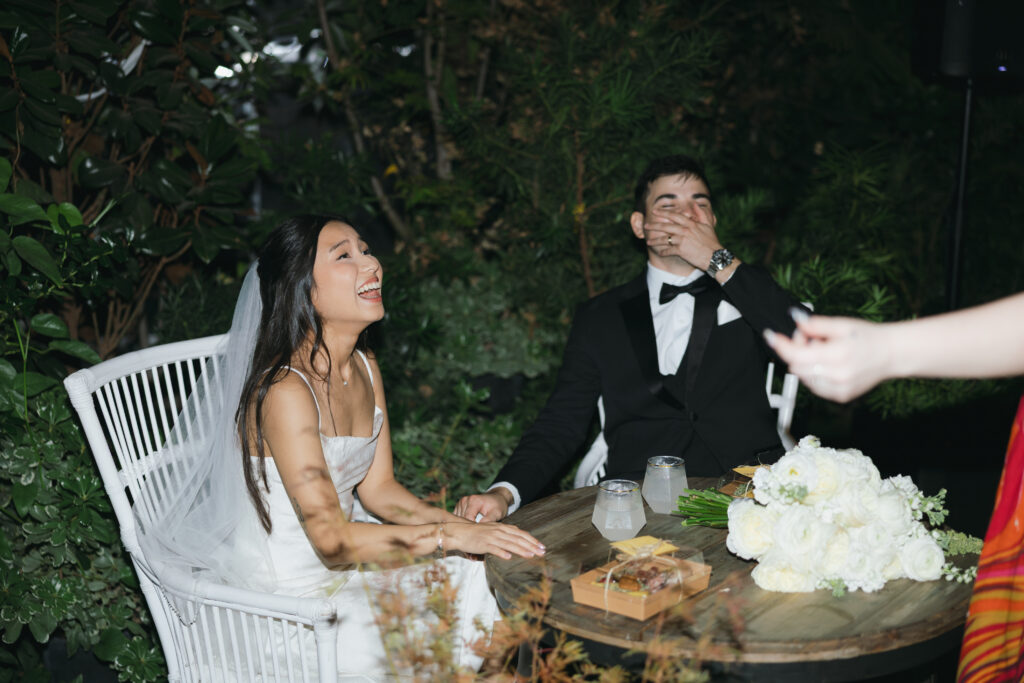 Couple laughing really hard during speeches, showcasing one of their intimate wedding ideas.