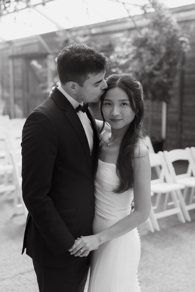 Groom kissing his bride's forehead.