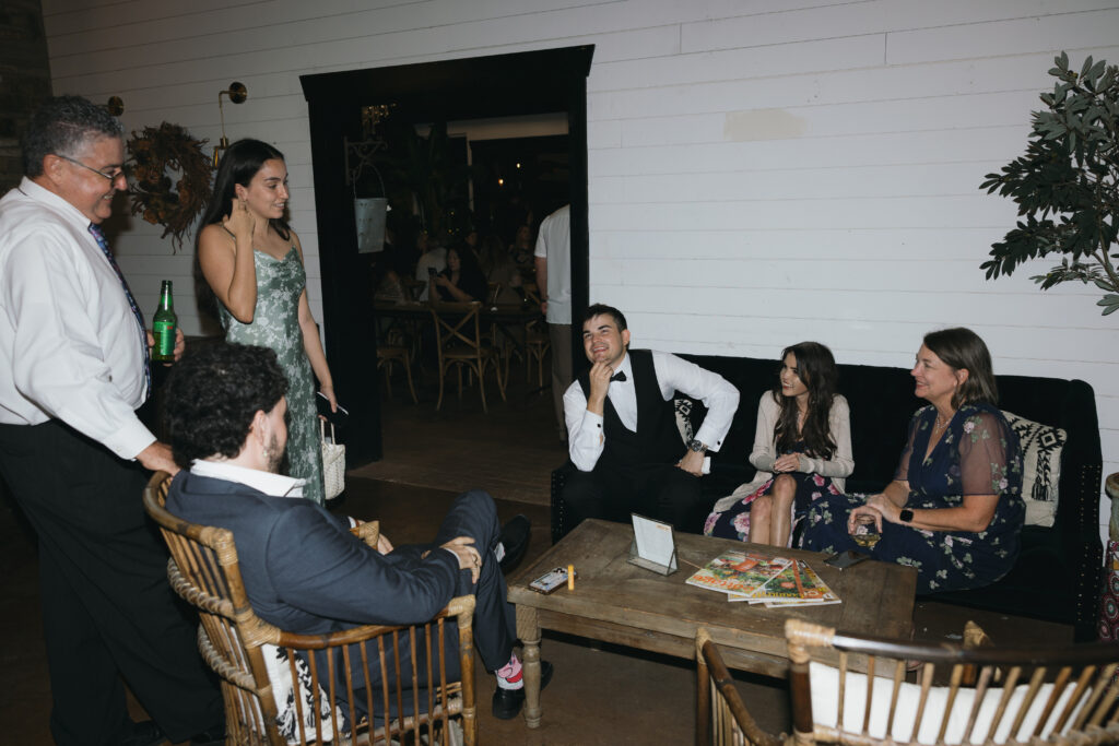 Groom sitting and talking with friends, which was one of his intimate wedding ideas to enjoy company.