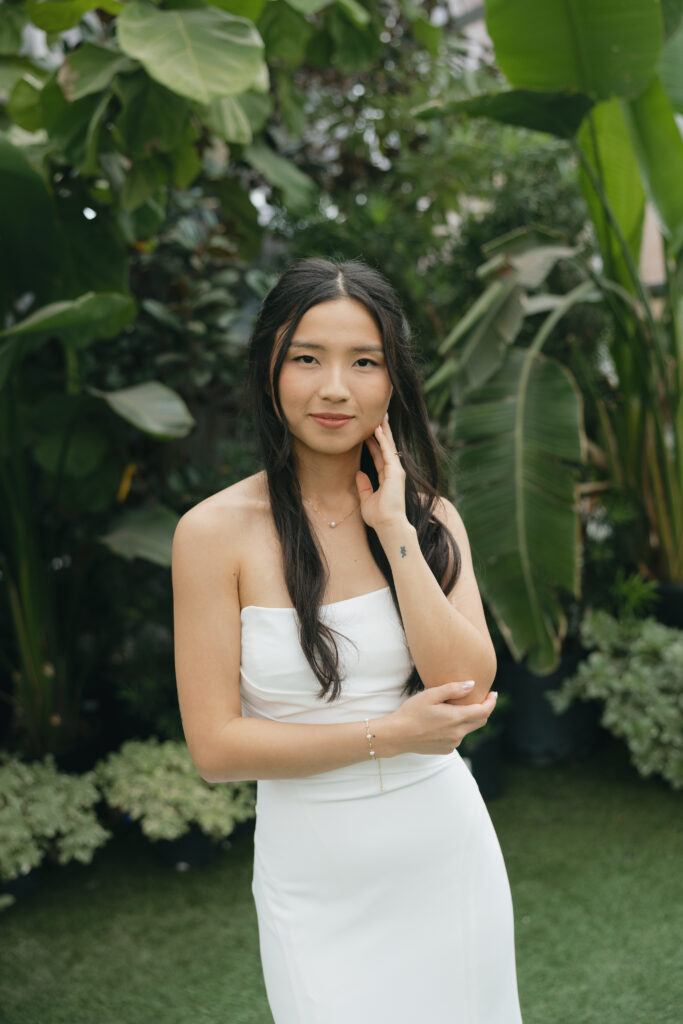 Bride looking at the camera with greenery behind her at Honey Locust Farms in Rockwall, Texas.