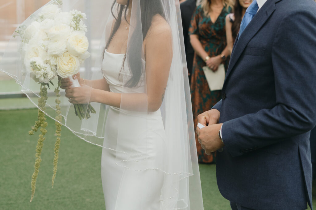 Close up of wedding gown and wedding flowers.
