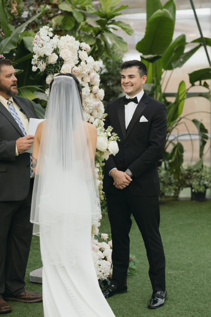 Groom smiling wide during the ceremony.
