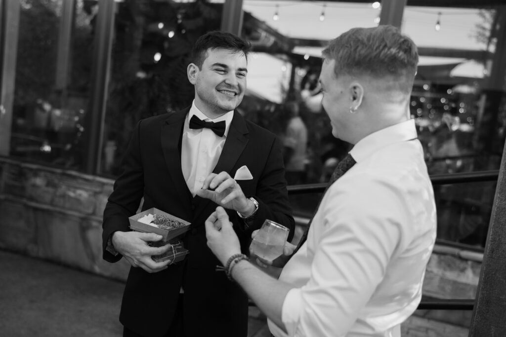 Groom laughing with a friend, one of his intimate wedding ideas to slow down and enjoy company.