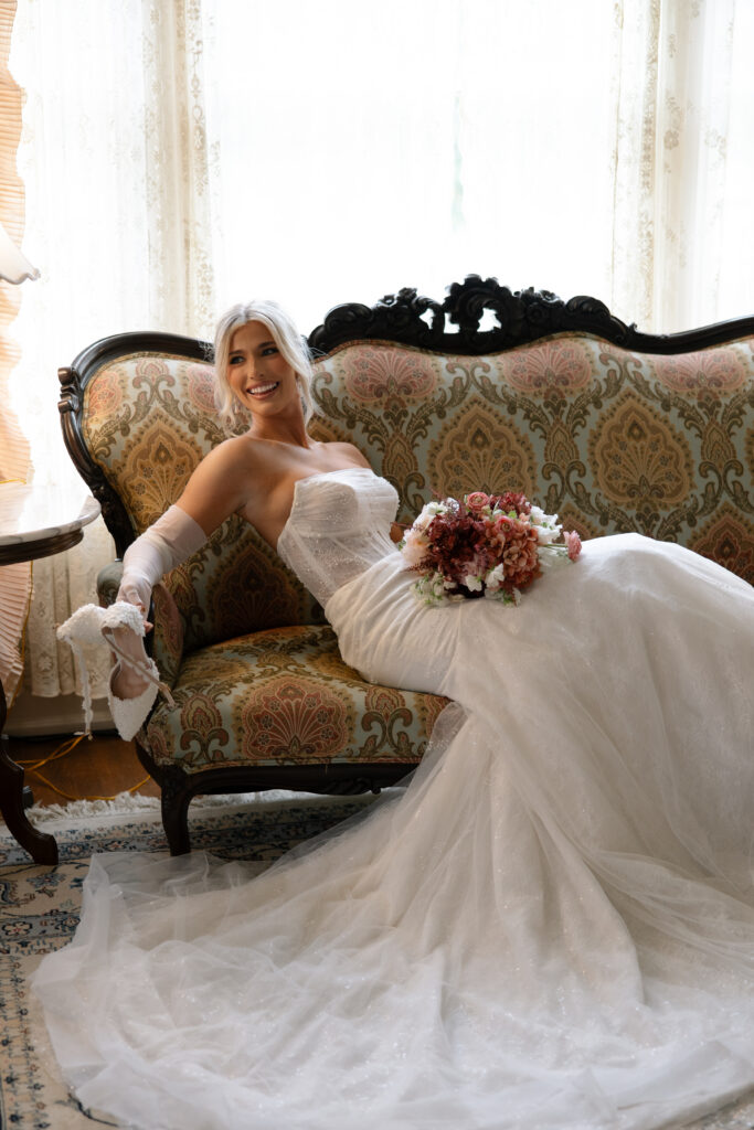 Bride laying on a couch at the Historic Aldredge House in Dallas, Texas.