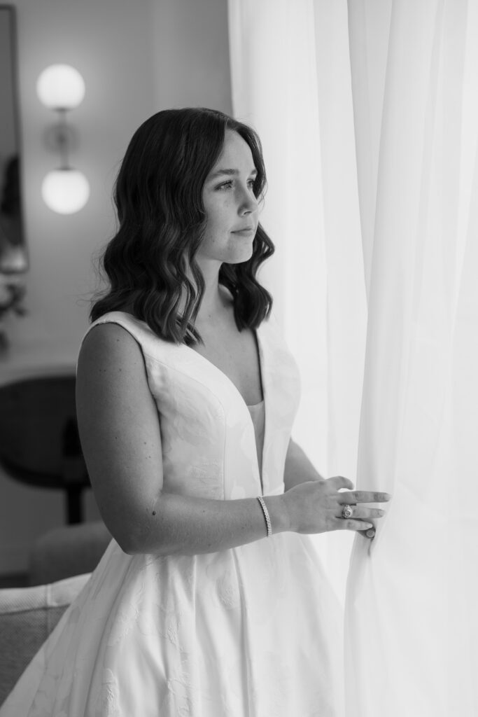 bride gazing out the window after getting ready for her wedding in dallas texas