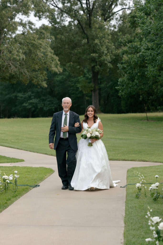 bride and father of the bride walk down the aisle for the wedding ceremony