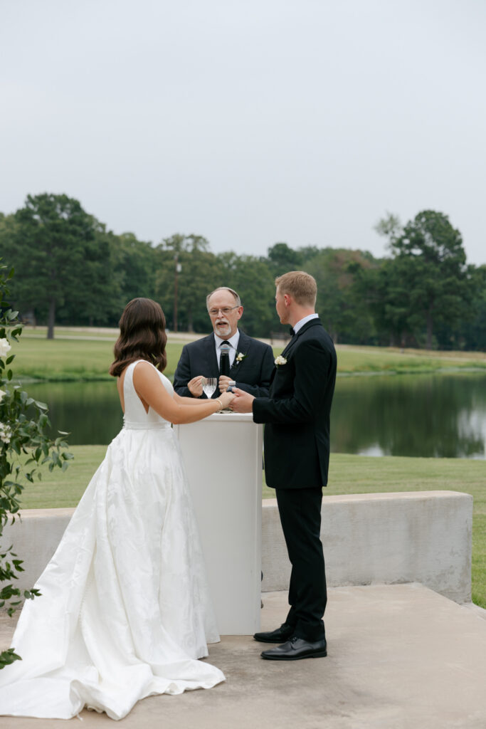 bride and groom preparing to take communion during the outdoor texas wedding