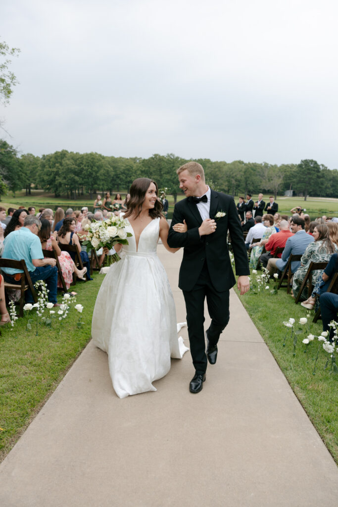 bride and groom smiling as they walk down the aisle after saying "I do." Wedding in Dallas Texas