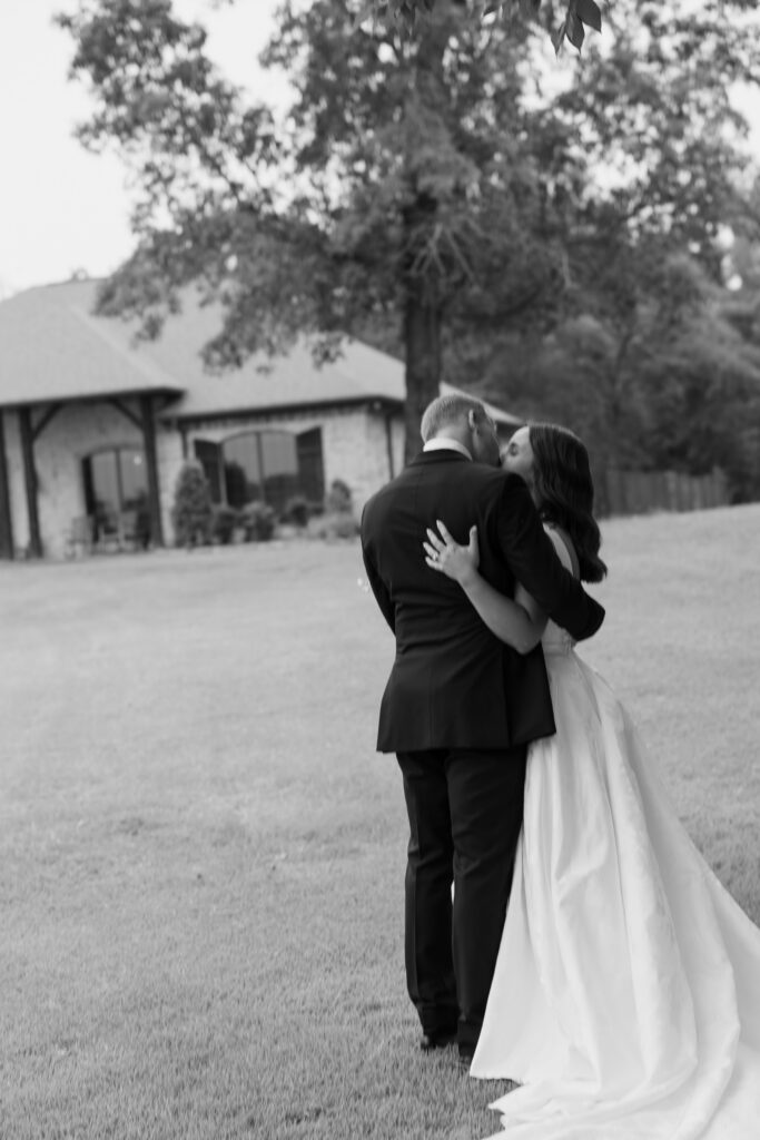 a black and white documentary image of the bride and groom kissing after their wedding ceremony. Dallas Texas wedding photographer