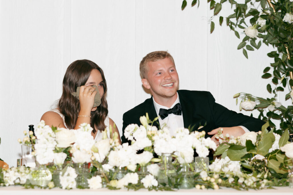 bride and groom shedding tears while listening to the toast